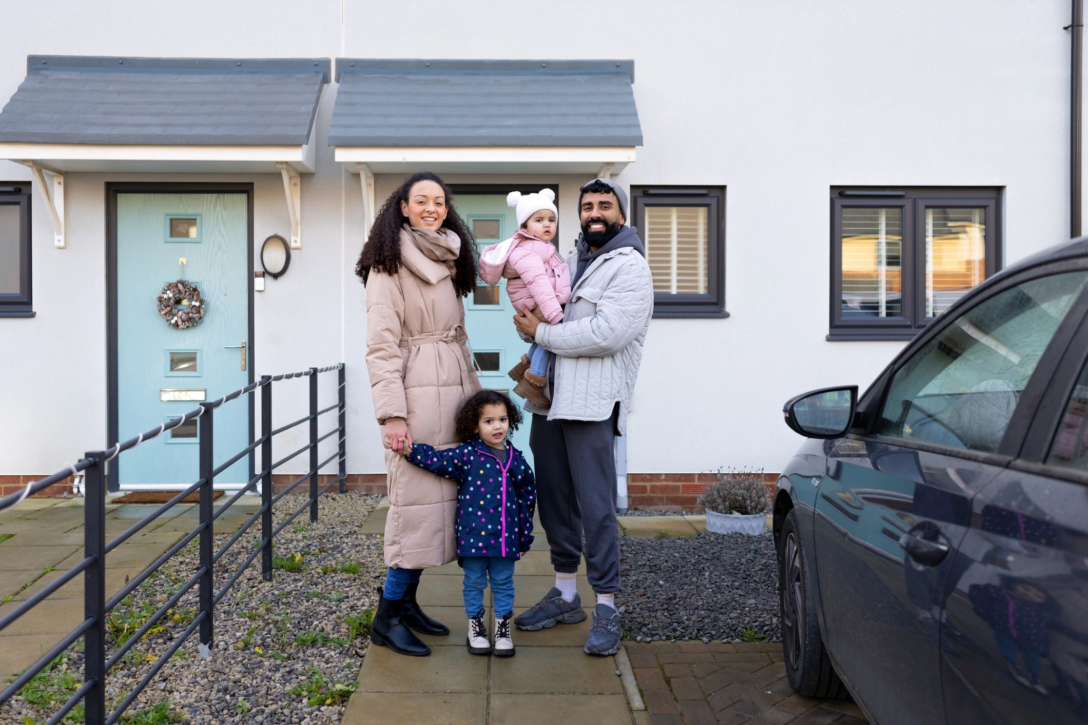 Happy new homeowners outside their home